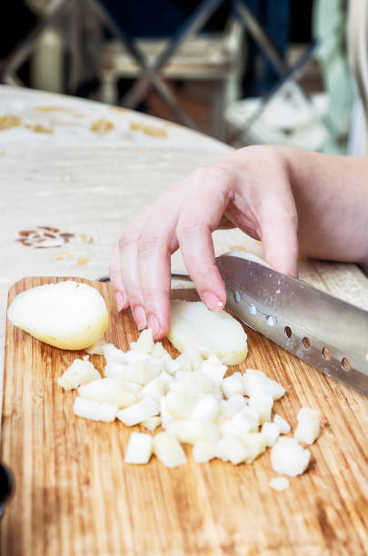 istock Woman's hand with a knife cutting the boiling potatoes 953454472