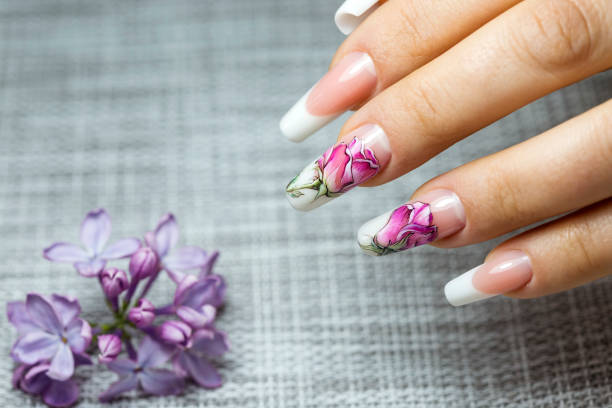 istock Beautiful multicolored flowers on a transparent lacquer on the nails 953458544