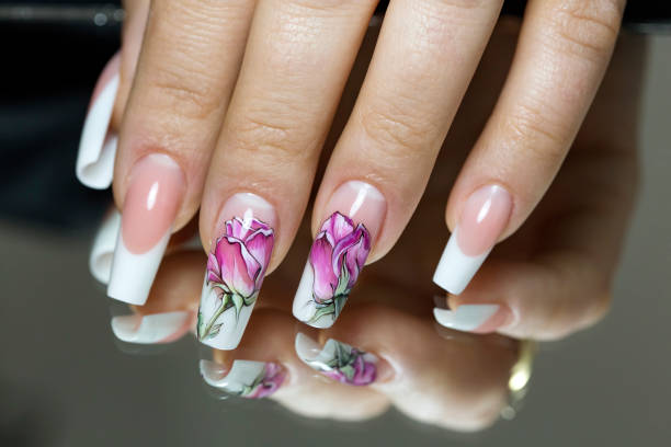 istock Beautiful multicolored flowers on a transparent lacquer on the nails 953458558