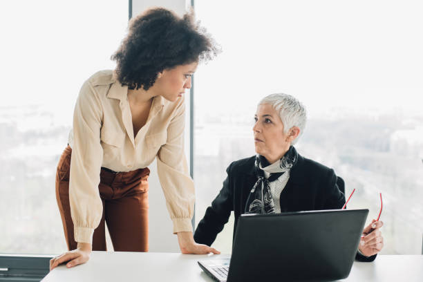 istock Female coworkers talking at office 953458602