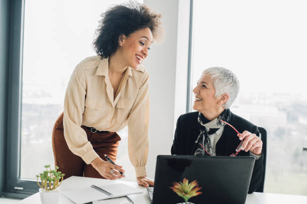 istock Female coworkers talking and smiling at office 953458608