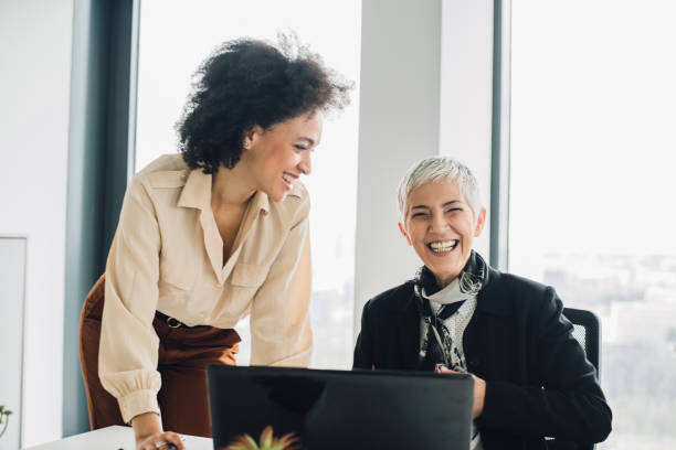 istock Female coworkers laughing at office 953458614