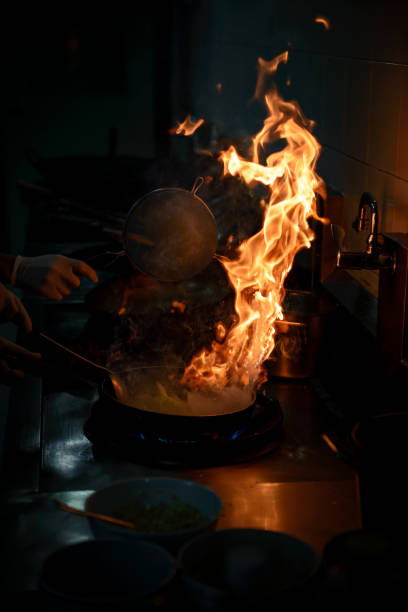 istock Chef cooking and doing flambe on food in restaurant kitchen 953459548