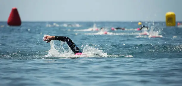 Group people in wetsuit swimming at triathlon