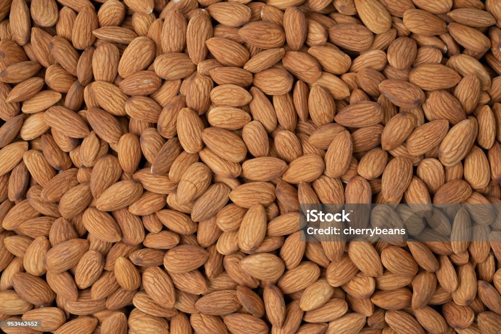 Almond nuts pile background. Roasted peeled almond nuts heap texture ,top view. Almond Stock Photo