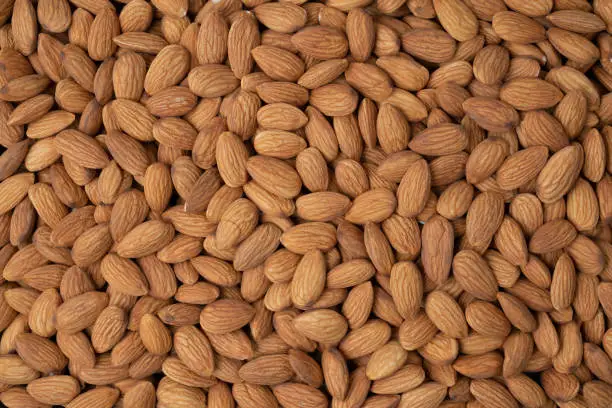 Photo of Almond nuts pile background.