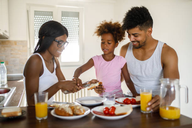 istock Young happy family having breakfast at home 953462696