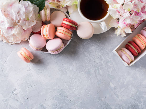 istock Macaroons and cup of coffee with flowers over white texture 953462820