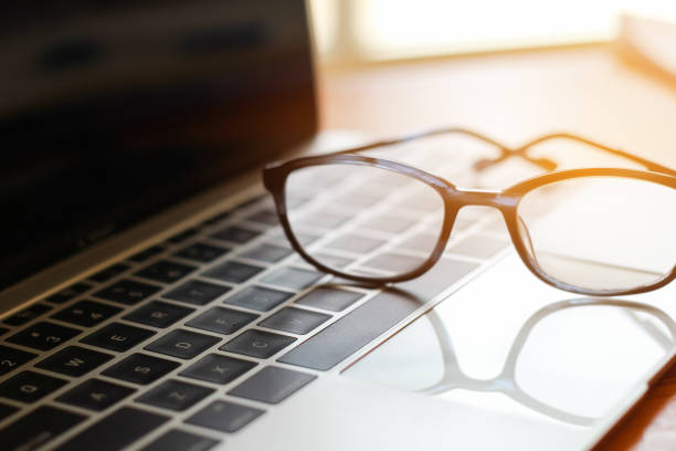 istock Eyes glasses put on computer laptop at business workplace in office with light background 953463116