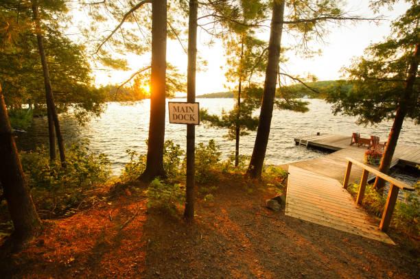 Adirondack chairs sitting on a wooden dock at sunset