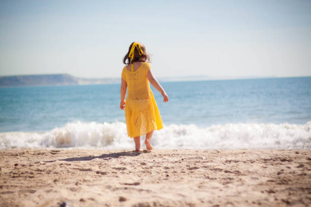istock Happy little girl running on the beach 953465738