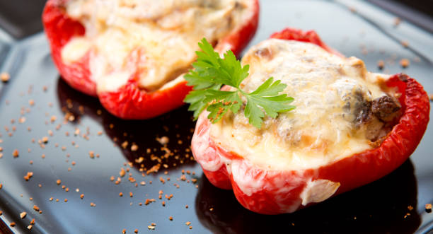 istock Stuffed Red bell peppers with mushrooms on the black plate 953468270
