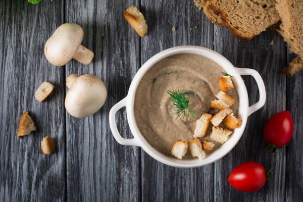 istock Mushroom cream soup with croutons on wooden background, selective focus 953468766