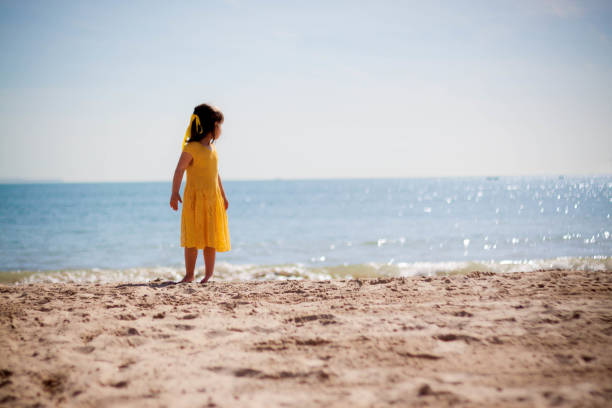 istock Happy little girl running on the beach 953469820