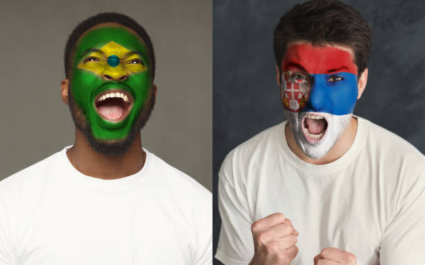 istock Emotional soccer fans with painted flags on faces 953470346