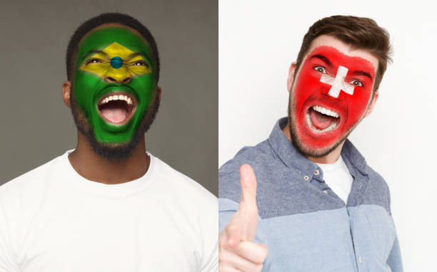 istock Emotional soccer fans with painted flags on faces 953470384