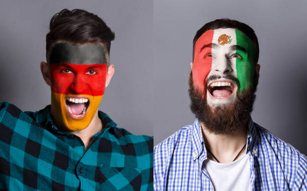 istock Emotional soccer fans with painted flags on faces 953470440
