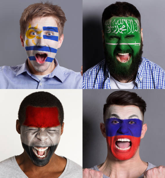 istock Emotional soccer fans with painted flags on faces 953470486