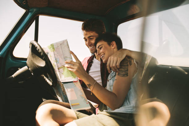istock Young travellers on a road trip looking at map 953470962