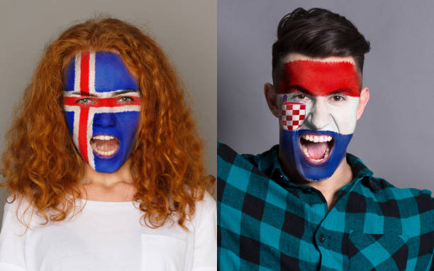 istock Emotional soccer fans with painted flags on faces 953471036