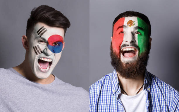 istock Emotional soccer fans with painted flags on faces 953471244