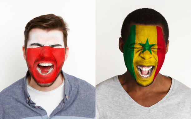istock Emotional soccer fans with painted flags on faces 953471944