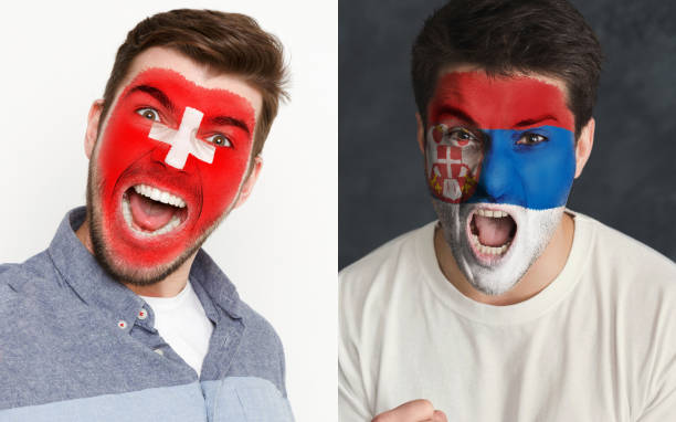 istock Emotional soccer fans with painted flags on faces 953472388