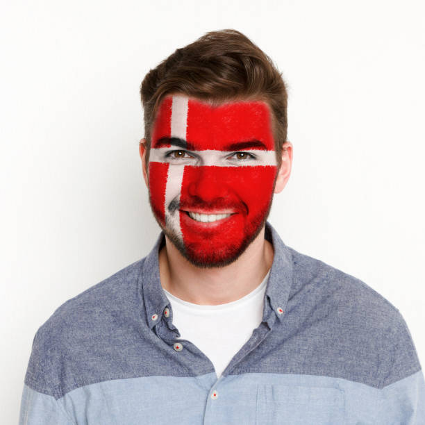 istock Young man with Denmark flag painted on his face 953472446