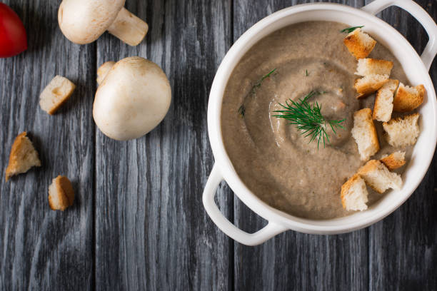 istock Mushroom cream soup with croutons on wooden background, selective focus 953472776