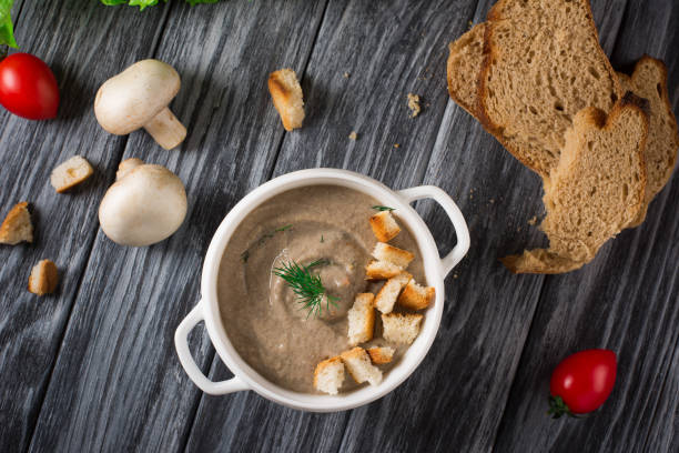 istock Mushroom cream soup with croutons on wooden background, selective focus 953473048