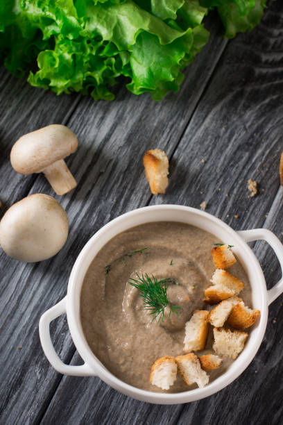 istock Mushroom cream soup with croutons on wooden background, selective focus 953473210