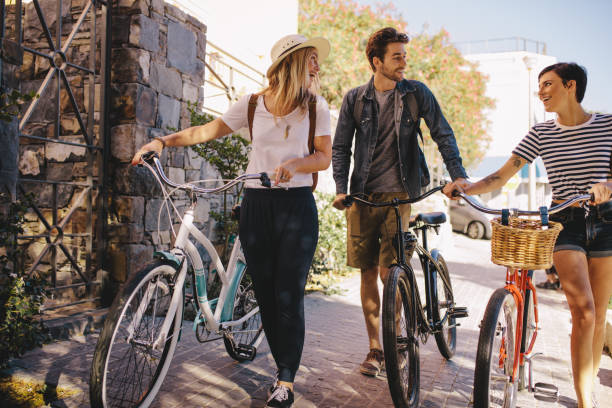 istock Friends with bikes walking outdoors in city 953475060
