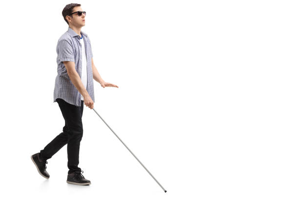 Blind young man with a cane walking Full length profile shot of a blind young man with a cane walking isolated on white background blind persons cane stock pictures, royalty-free photos & images