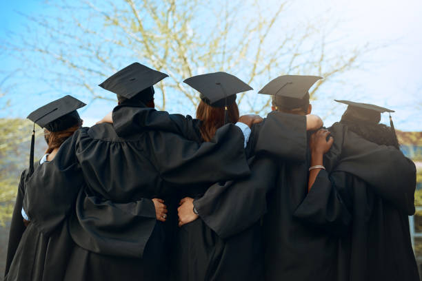 That's a wrap folks! Rearview shot of a group of young students embracing on graduation day cap hat photos stock pictures, royalty-free photos & images