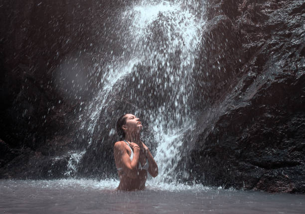 istock Beautiful young woman enjoy a waterfall. 953497338