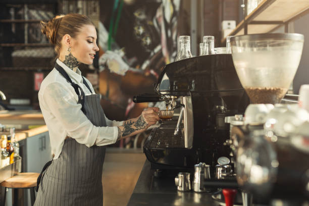 istock Tattooed barista making coffee in professional coffee machine 953498944