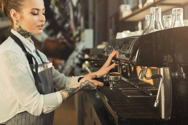 istock Tattooed barista making coffee in professional coffee machine 953499020