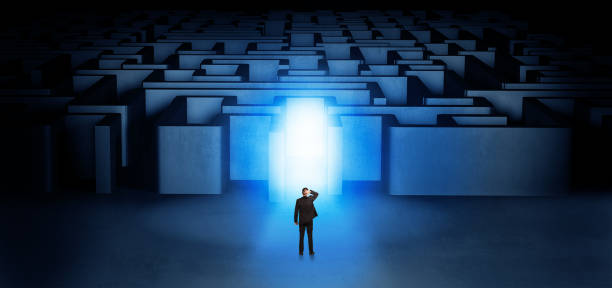 istock Lost businessman standing at illuminated labyrinth entrance 953503272