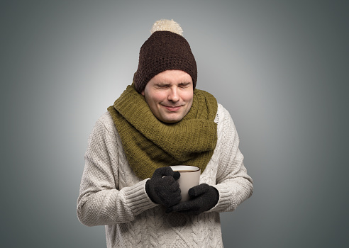 Handsome young boy freezing in warm clothing with copy space