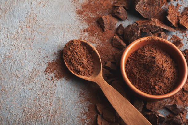 istock Crushed chocolate pieces and cocoa on gray background 953509112