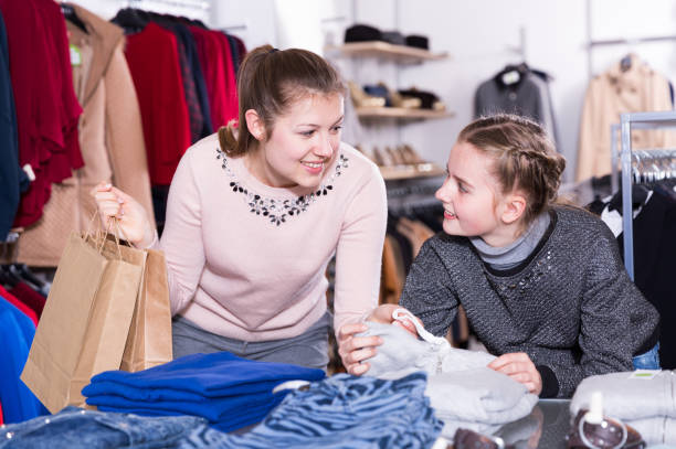 istock Daughter with mother choosing clothes in store 953509220