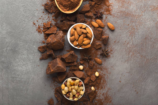 istock Crushed chocolate bar pieces and cocoa on gray background, top view 953510378