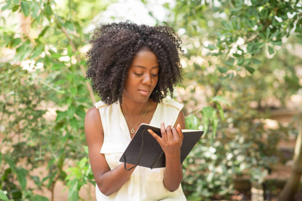 istock Content young pretty black woman making notes in park 953511944