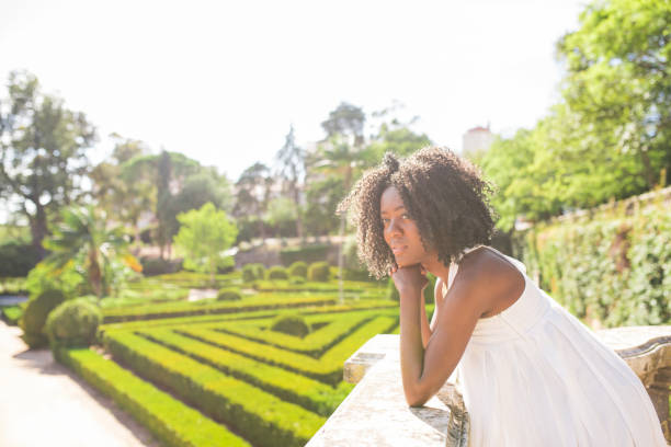istock Pensive young black woman leaning on stone railing in park 953511972