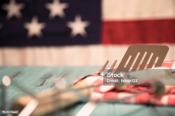 Outdoor Grilling Bbq Utensils On Rustic Picnic Table With Usa Flag Stock Photo - Download Image Now