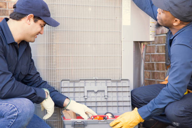 istock Multi-ethnic team of blue collar air conditioner repairmen at work. 953514016