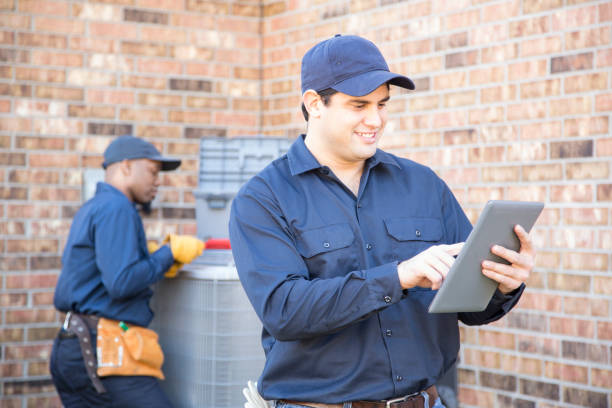 istock Multi-ethnic team of blue collar air conditioner repairmen at work. 953514772