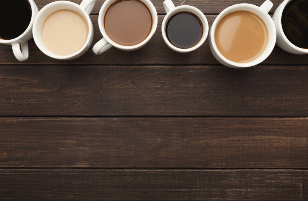 istock Different types of coffee in cups on wooden table, top view 953515944