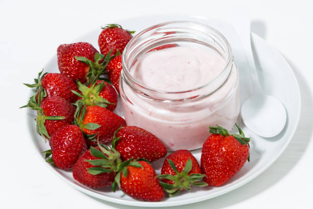 istock fruit yogurt in glass jar and fresh strawberries, top view 953516458