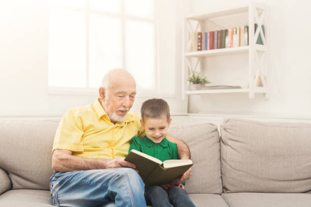 istock Senior man reading book for his grandchild 953518856